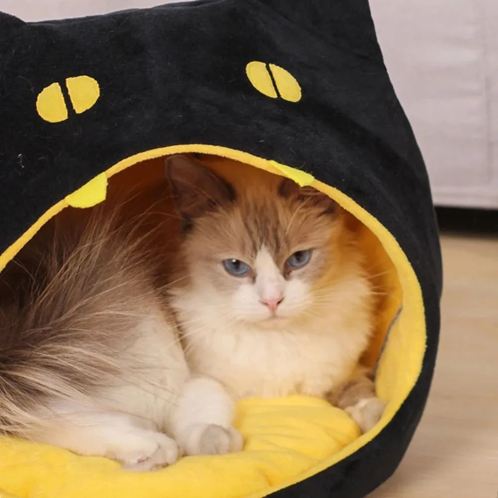 Grey covered cat cave pet bed with cat face design and anti-slip bottom.