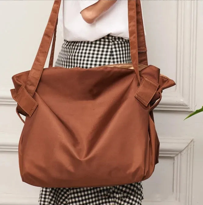 Women's black crossbody shoulder bag made from Oxford cloth with a large expandable storage compartment.