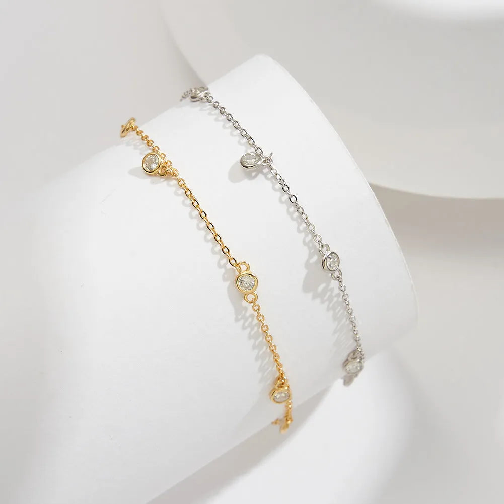 Women's sterling silver anklet with a geometric zirconium pendant on an ankle