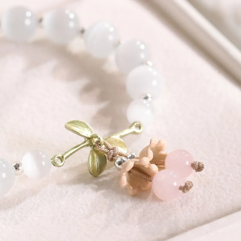 Women's bracelet with multiple diamond-shaped cat's eye opal beads on a string.
