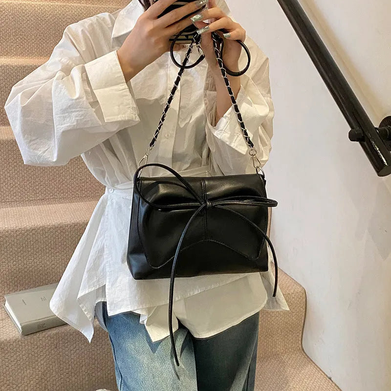Women's black crossbody underarm bag with horizontal square shape and sewing line detailing