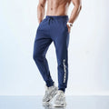 Men's grey blue sweatpants with ankle-tied cuffs laid flat, showing mid-waist and tapered leg.