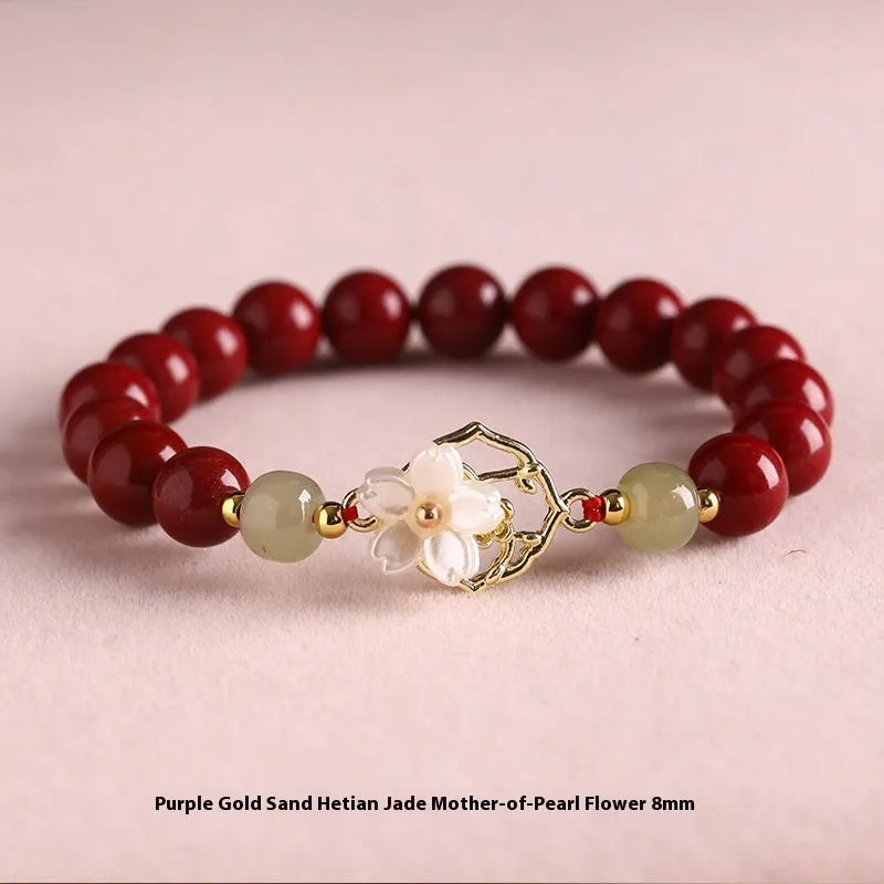 Handcrafted cinnabar bracelet with white Hetian jade butterfly charm, Bells of Ireland, and lotus details in New Chinese style.
