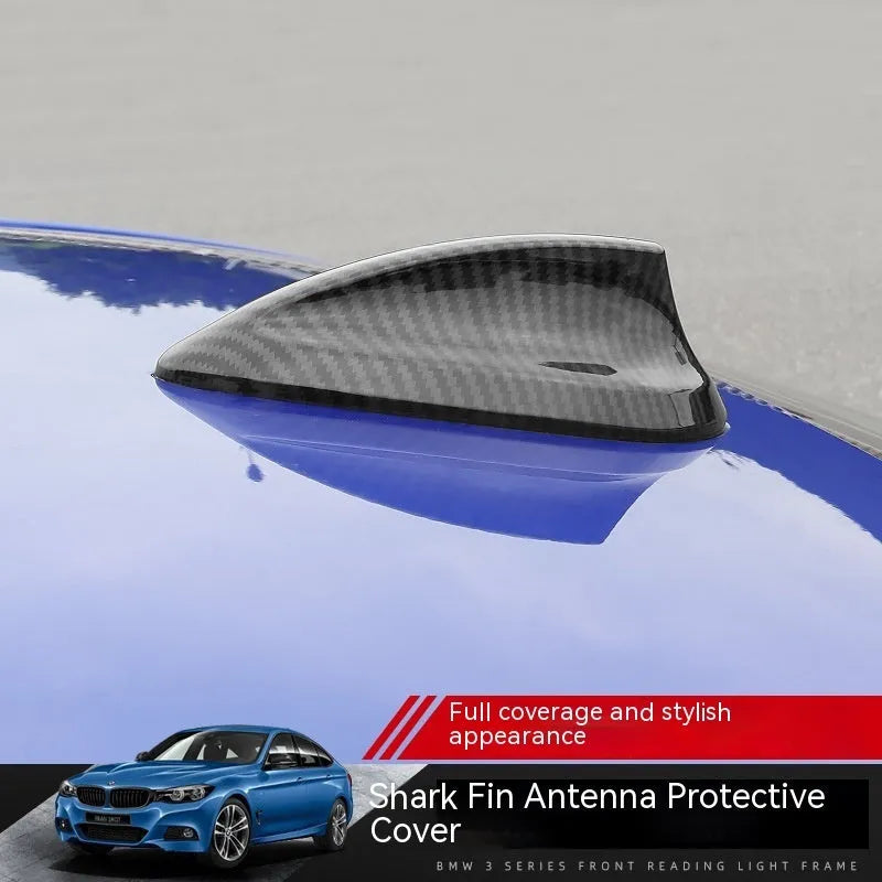 BMW shark fin antenna cover in carbon fibre and piano black finishes on a car roof.