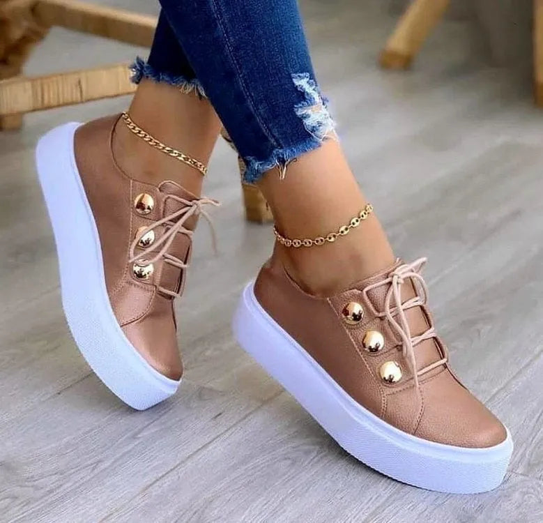 Women's white lace-up flats sneakers with rivet detailing on round toe, showing front tie lacing and 3-5cm heel