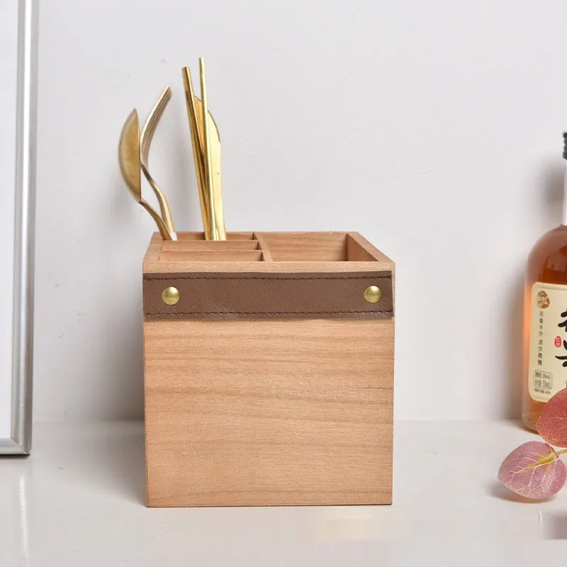 Wooden kitchen storage box with internal grid divider for organising knives, forks, and chopsticks.