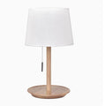 Walnut colour solid wood bedside lamp with a white fabric shade on a wooden surface.