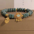 Close-up of a women's bracelet with natural emerald green jade abacus beads and a metallic alloy safety lock clasp.