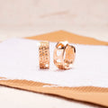Rose gold hollowed-out heart earrings with circular 2.5cm diameter on white background