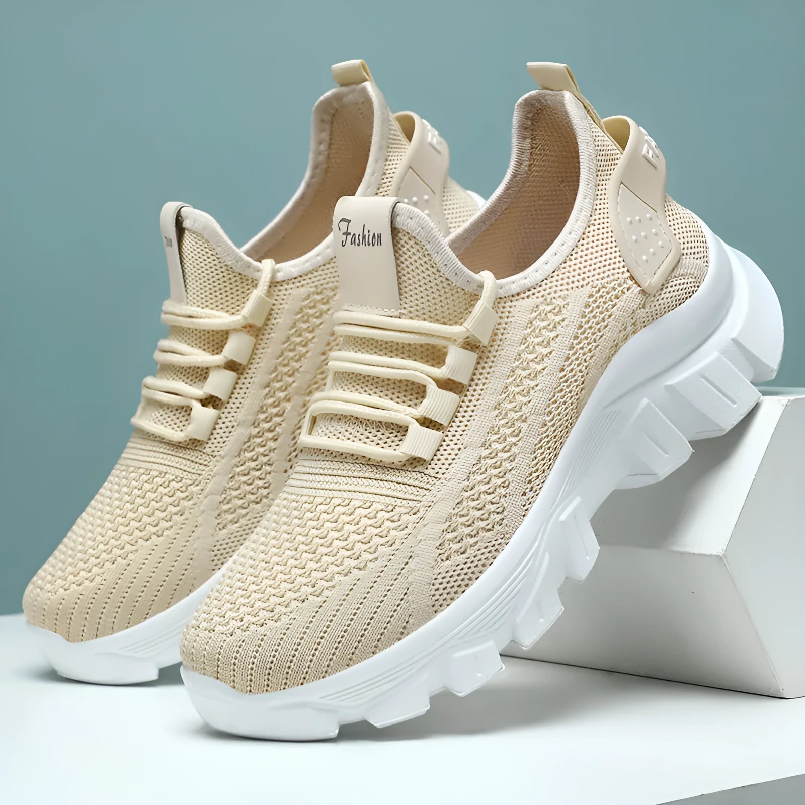 Women's Flyknit sneakers in beige with flat heel, round toe, and lace-up front, showing breathable upper and PVC sole