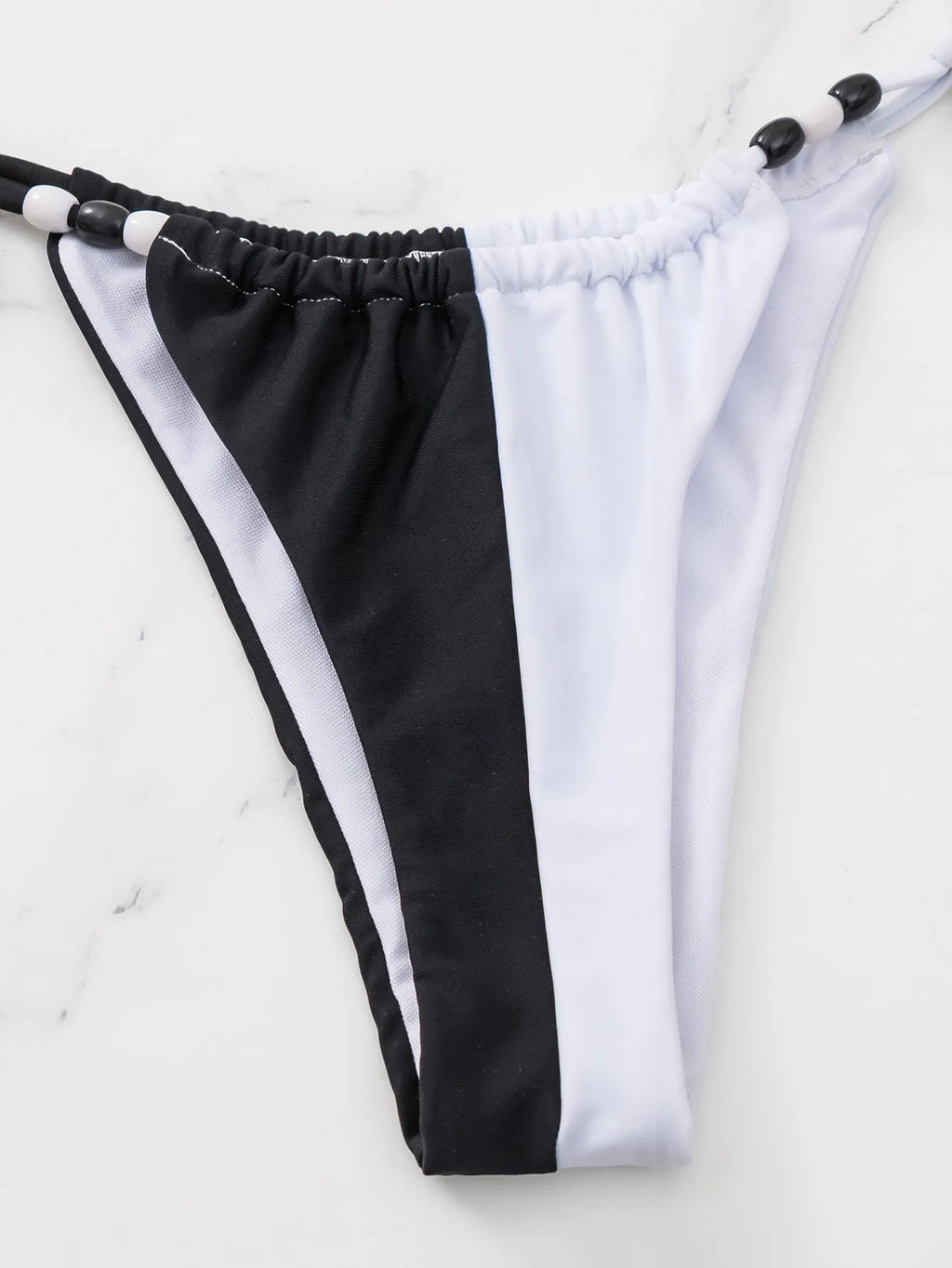 Women's black and white lace-up bikini swimsuit with triangle cup.