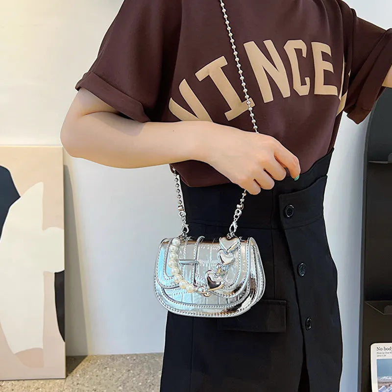 Laser Pearl Tote Saddle Girl Mini crossbody bag in gold colour showing horizontal square design and shoulder strap
