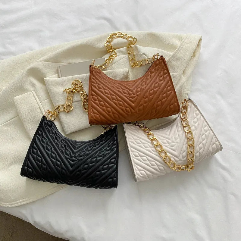 Brown pleated chain baguette shoulder bag with adjustable strap and soft carry handle showing three-dimensional pocket design