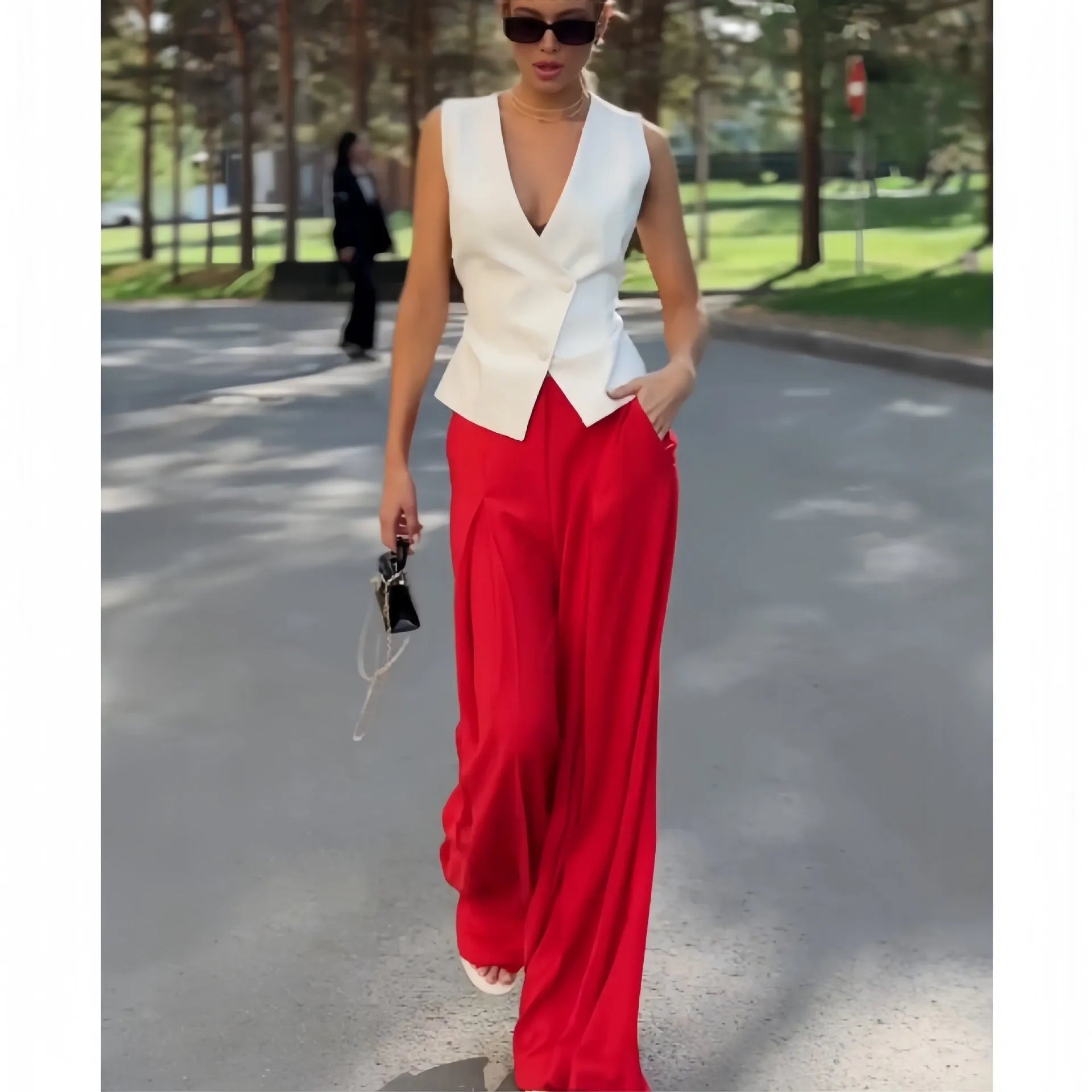 Beige women's sleeveless deep V-neck top and high-waist wide-leg trousers two-piece set on a hanger.