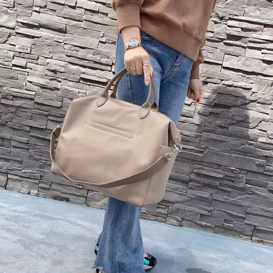 Nylon waterproof shoulder bag with leather handles in black or light khaki colour