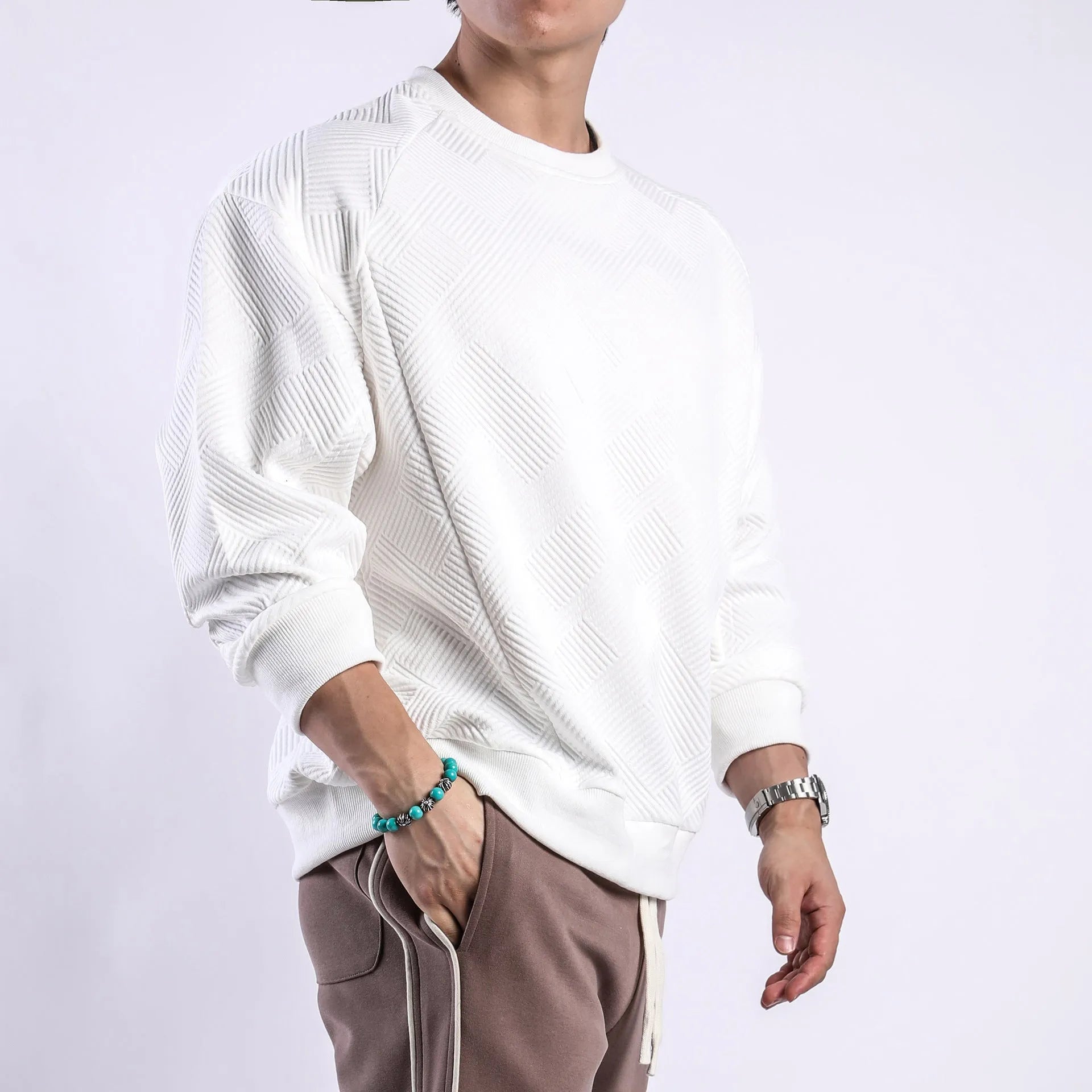 Men's solid colour long-sleeved sweater in twill jacquard fabric, shown in a loose fit with a round neck.