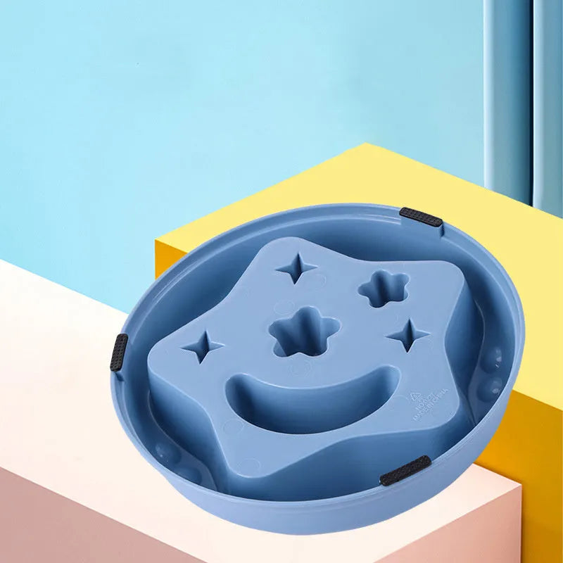 Moon star wings design slow feed dog bowl in blue, shown on a floor.