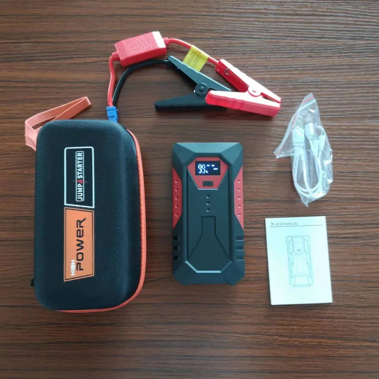 Red 12V car emergency jump starter power bank with battery clamps and 18800mAh capacity