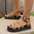 Black outdoor sandals with thick rubber sole and adjustable strap buckle closure showing round toe design