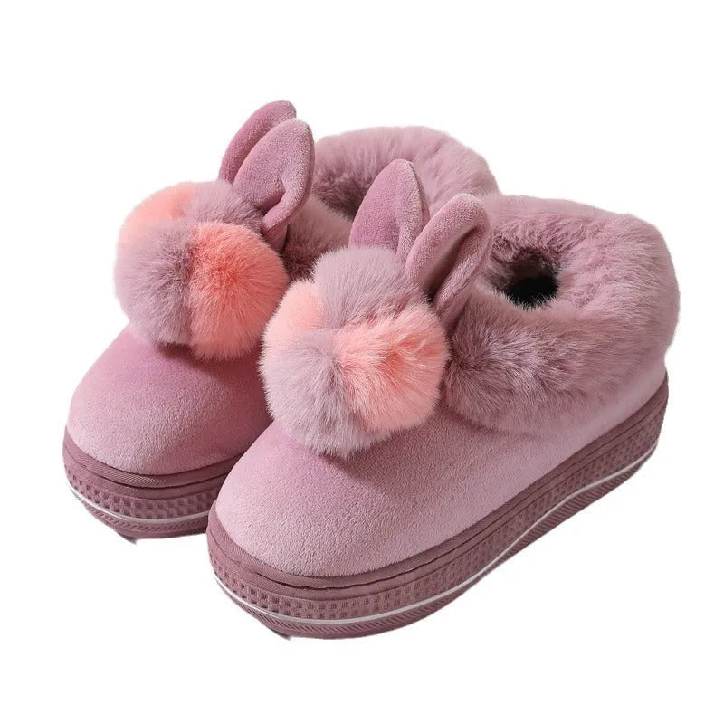 A pair of grey high heel winter slippers with a thick sole and plush upper, shown on a white background.