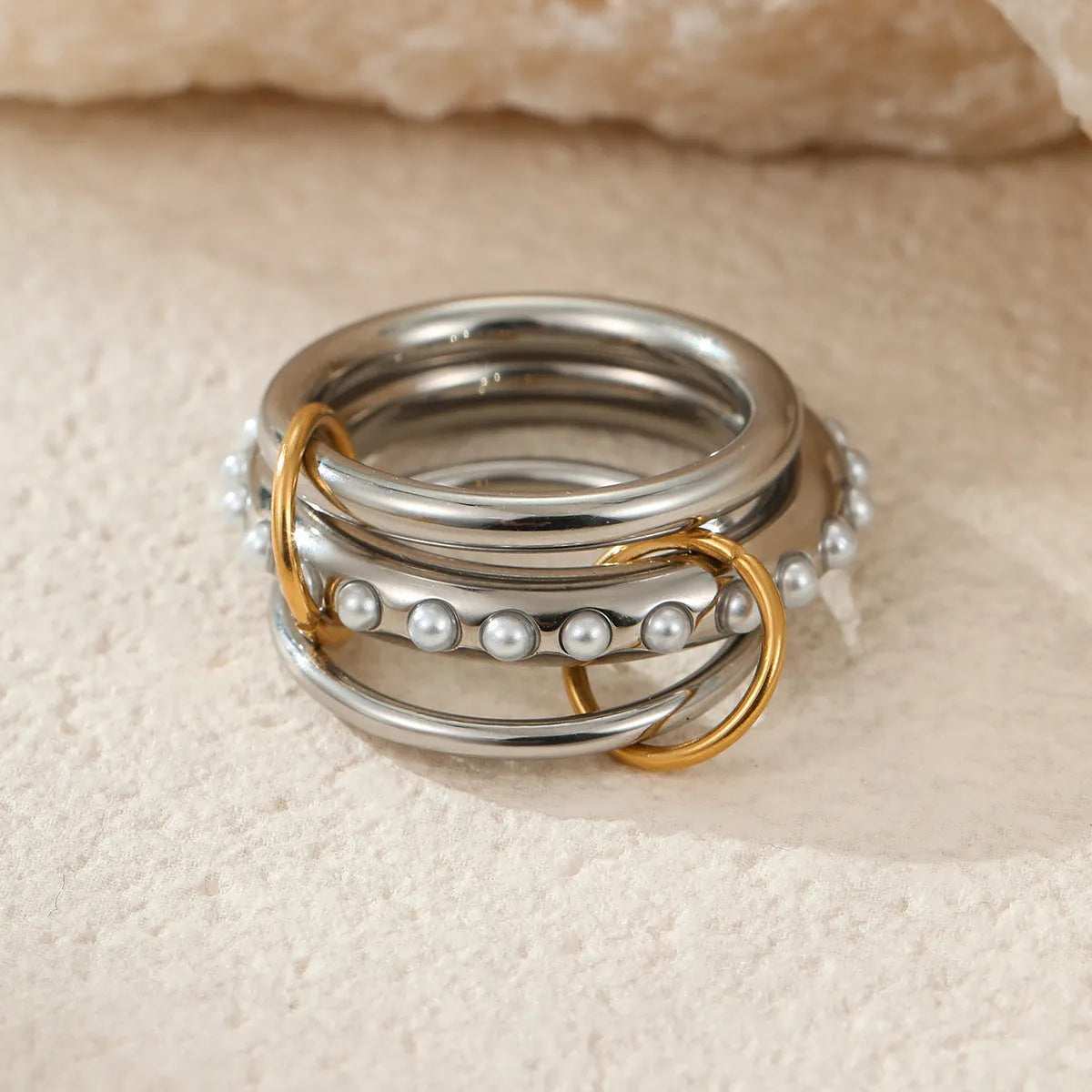 Stacked stainless steel rings with 18K gold plating in three colour variations, showing adjustable free size design
