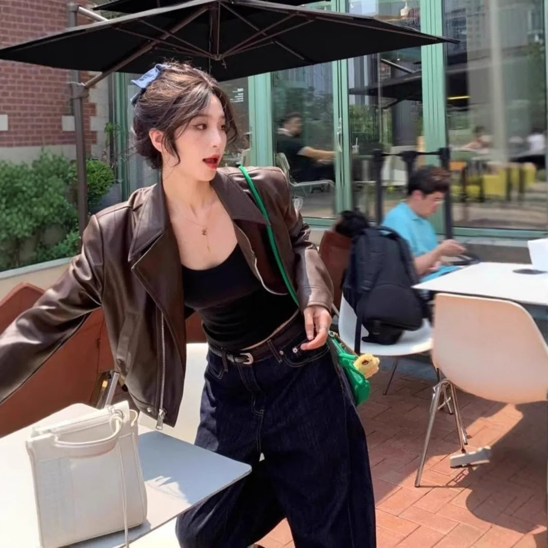 Brown women's retro slim-fit imitation leather jacket with a pocket on a hanger.