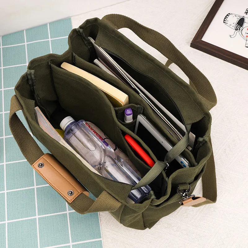 Horizontal square canvas tote bag with side zipper compartments and internal organisation pockets
