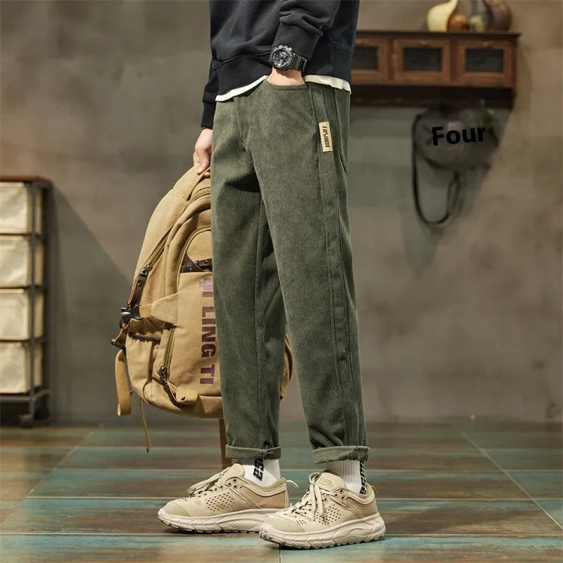 Men's tapered corduroy trousers in army green showing straight-leg street fashion style