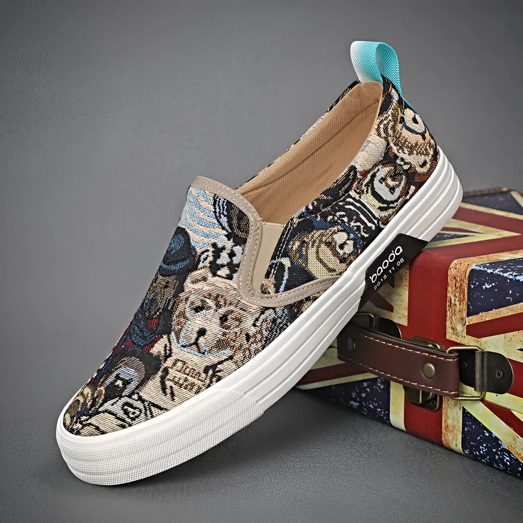 A pair of khaki-coloured canvas slip-on sneakers with a low-top profile, round toe, and vulcanised rubber sole on a plain background.