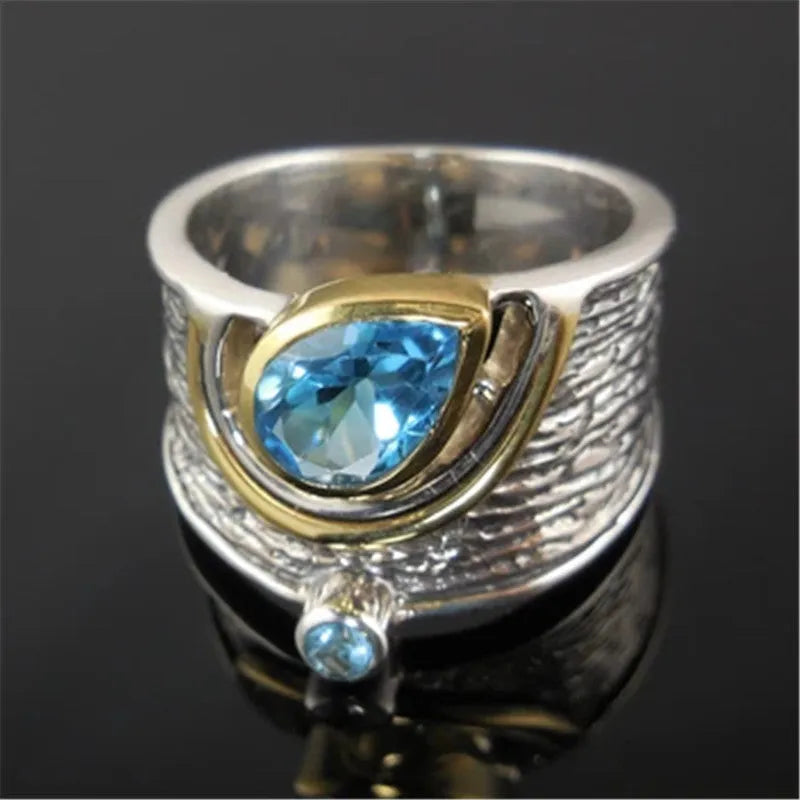 Drop-shaped blue zircon ring with inlaid stones on alloy band, showing sizes 6-10 for women's jewellery.