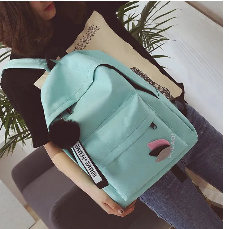 Casual canvas college schoolbag with leaf pattern in green, shown with size and anti-theft features.