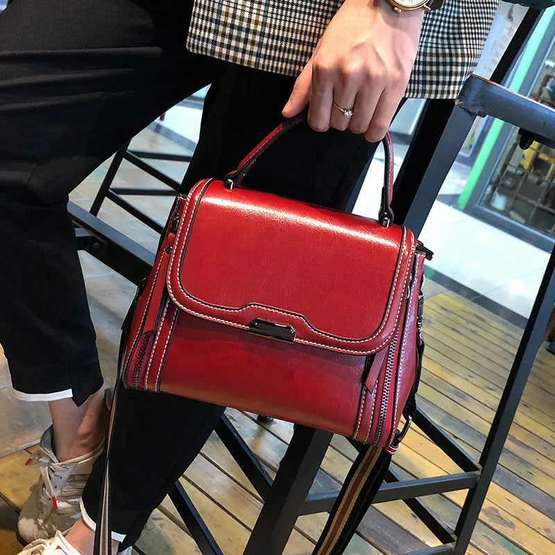 Women's brown genuine oil wax leather messenger bag with double shoulder straps and visible sewing lines