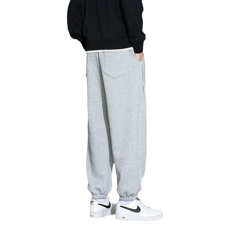 Men's loose grey cotton sports trousers with elastic waistband on hanger