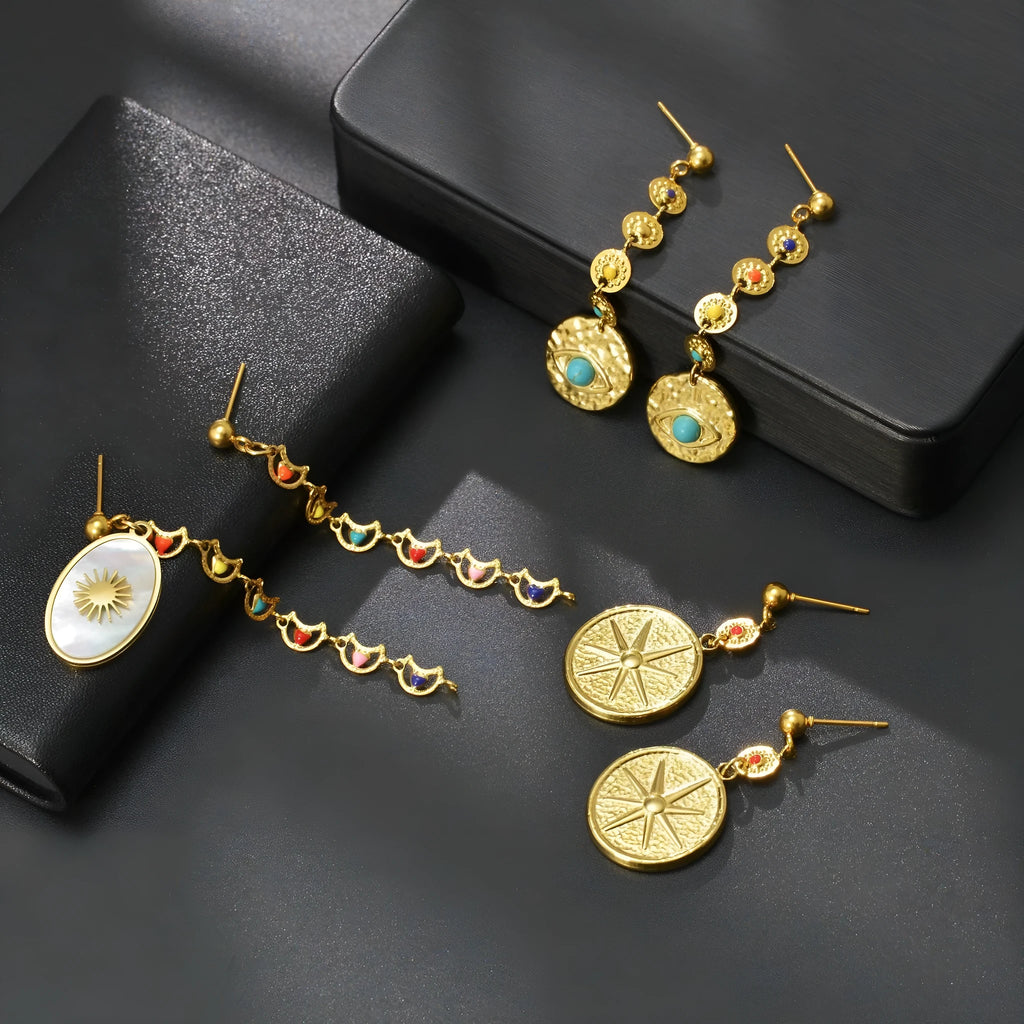 Three pairs of geometric stainless steel earrings showing Eight Awn Star, Eye, and Shell Sun designs.