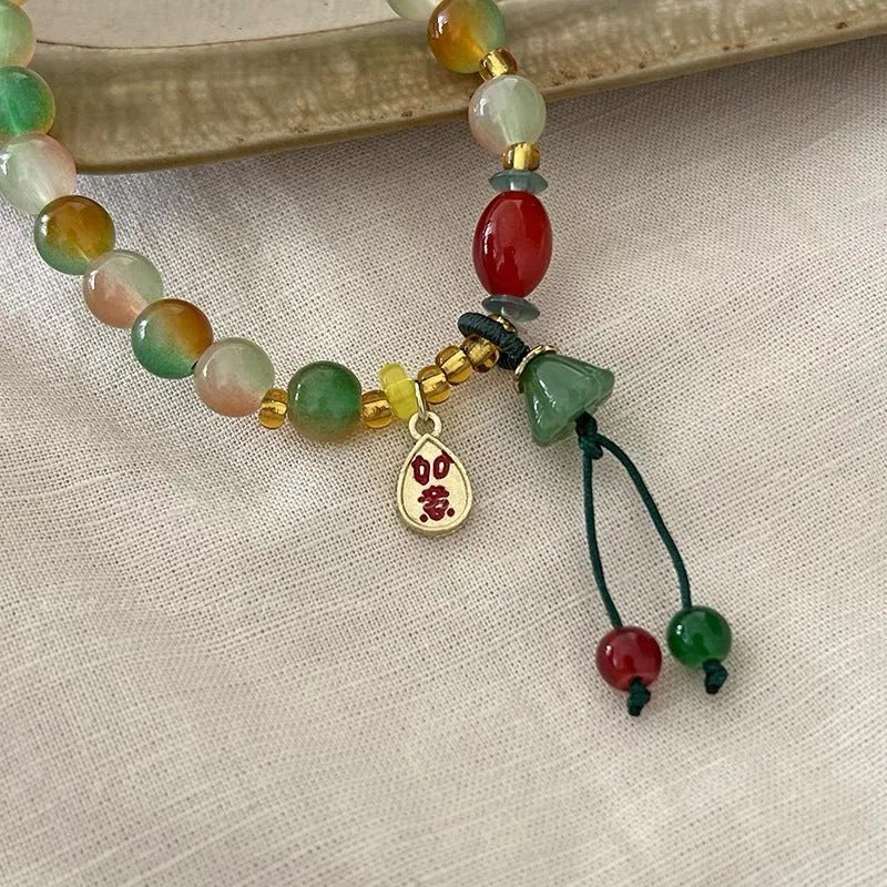 Handmade adjustable bracelet with a detailed lotus charm on a mixed material band.