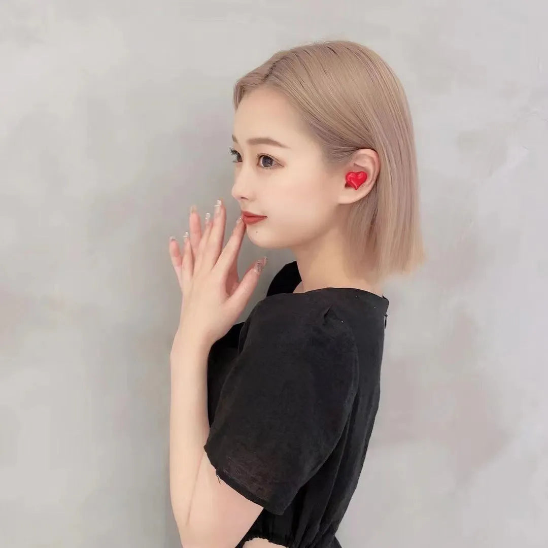 Heart-shaped wireless Bluetooth headphones in red or pink colour with charging cable