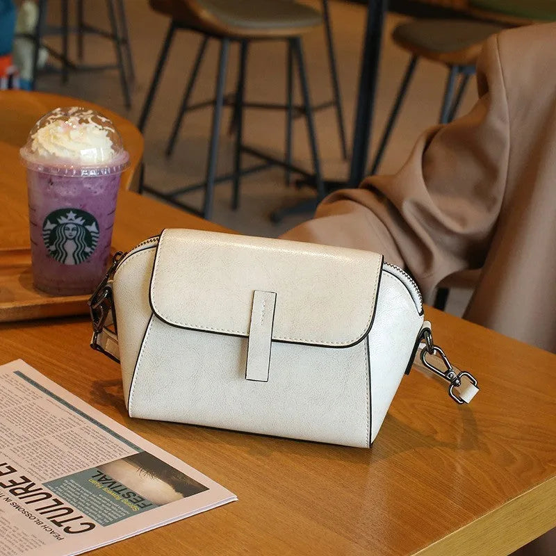 Women's brown oil wax cowhide shell messenger bag with cross-body strap and exterior sandwich pocket