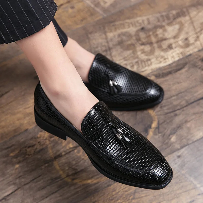 Men's black pointed slip-on leather shoes with tassel detailing on a low-top upper for business wear
