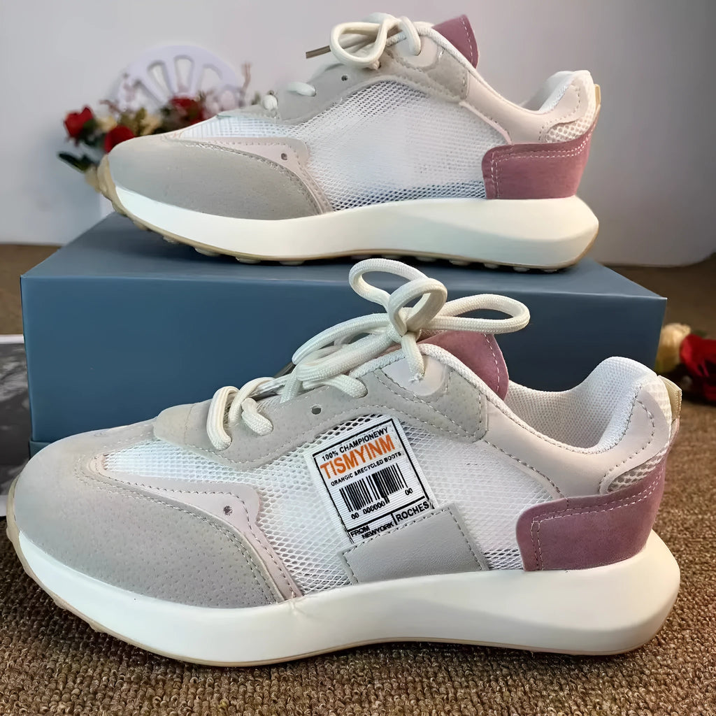 Women's grey and pink low-top retro sneaker with round toe and flat rubber sole.