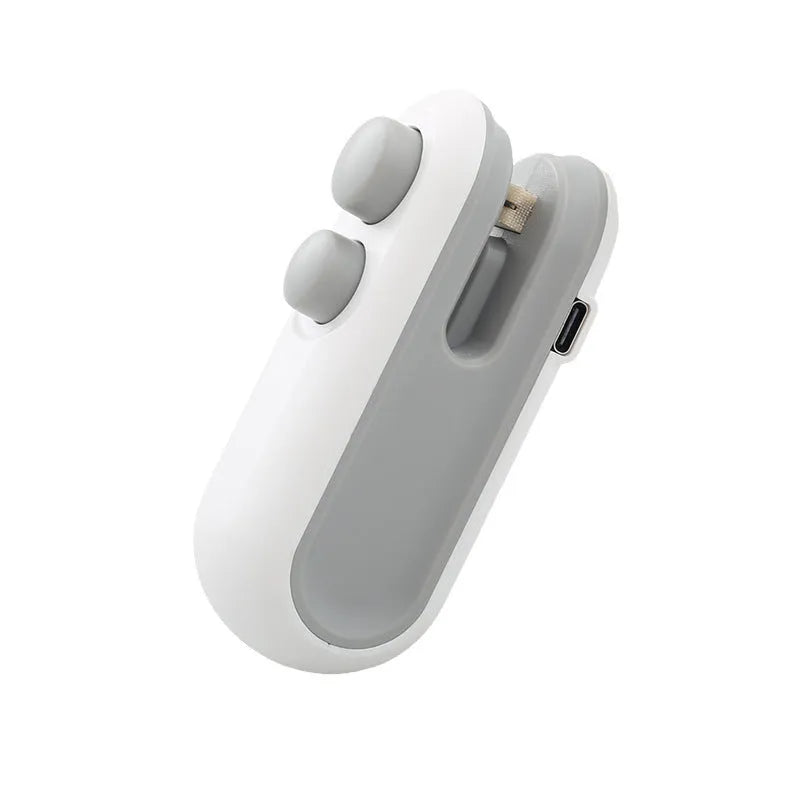 Blue and white handheld USB heat sealer with cutter blade on a magnetic metal surface.