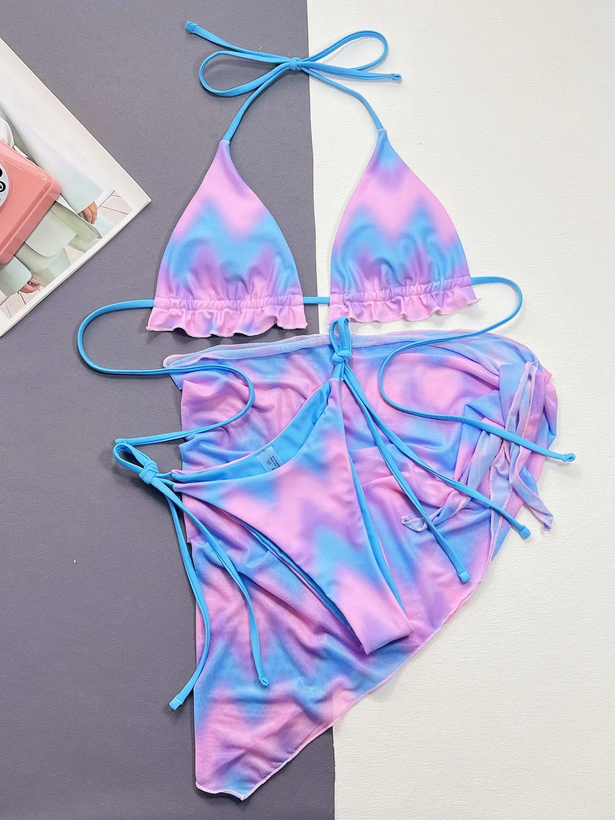Women's tie-dye patterned bikini swimsuit with a removable skirt, showing bra top and briefs.