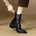 Women's black pointed-toe ankle boots with a short shaft and a low heel on a plain background.