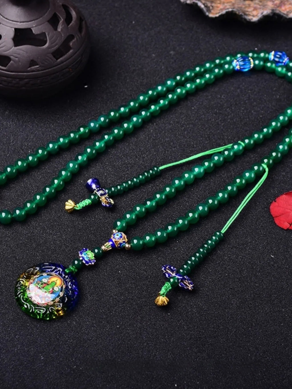 Green agate beaded bracelet with a multi-circle 108-bead thangka pendant on a wrist.