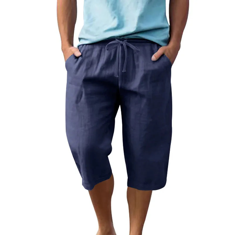 Men's solid colour linen shorts in a loose, cropped style on a drawstring waist.
