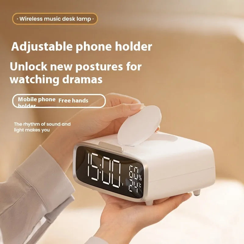 White Bluetooth speaker and wireless charging pad with integrated colour-changing night light on a bedside table.