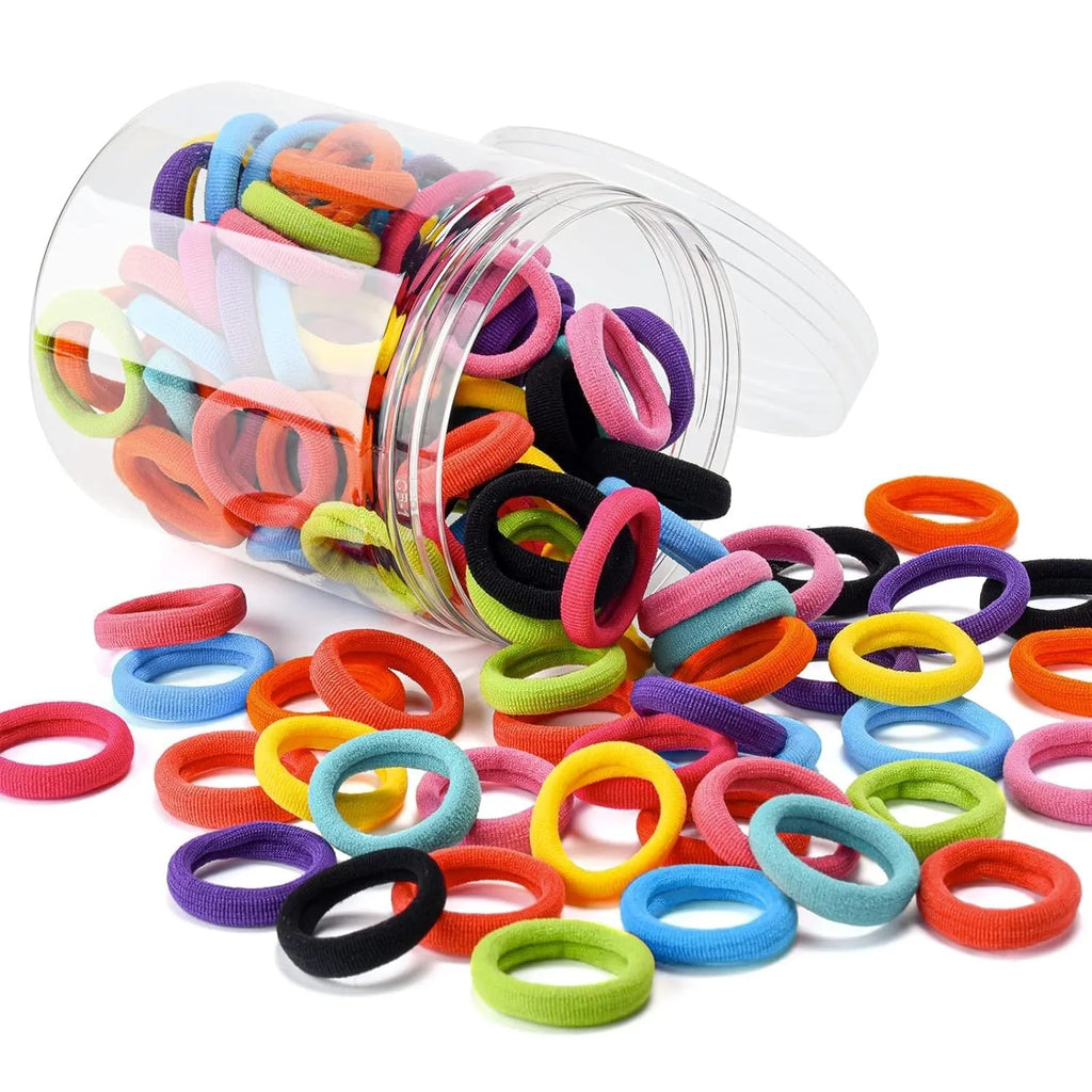 Multicoloured assortment of 100 small, seamless cotton hair ties for babies and toddlers in a jar.