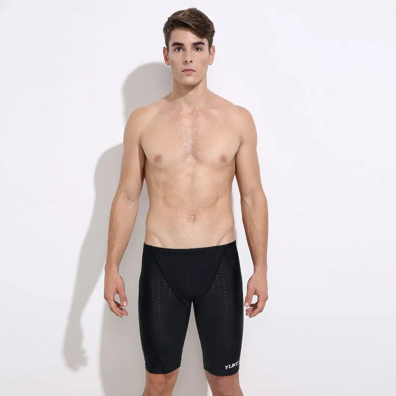 Men's black swimming set with briefs, goggles, cap, ear plugs, nose clip, and a carry bag laid out.
