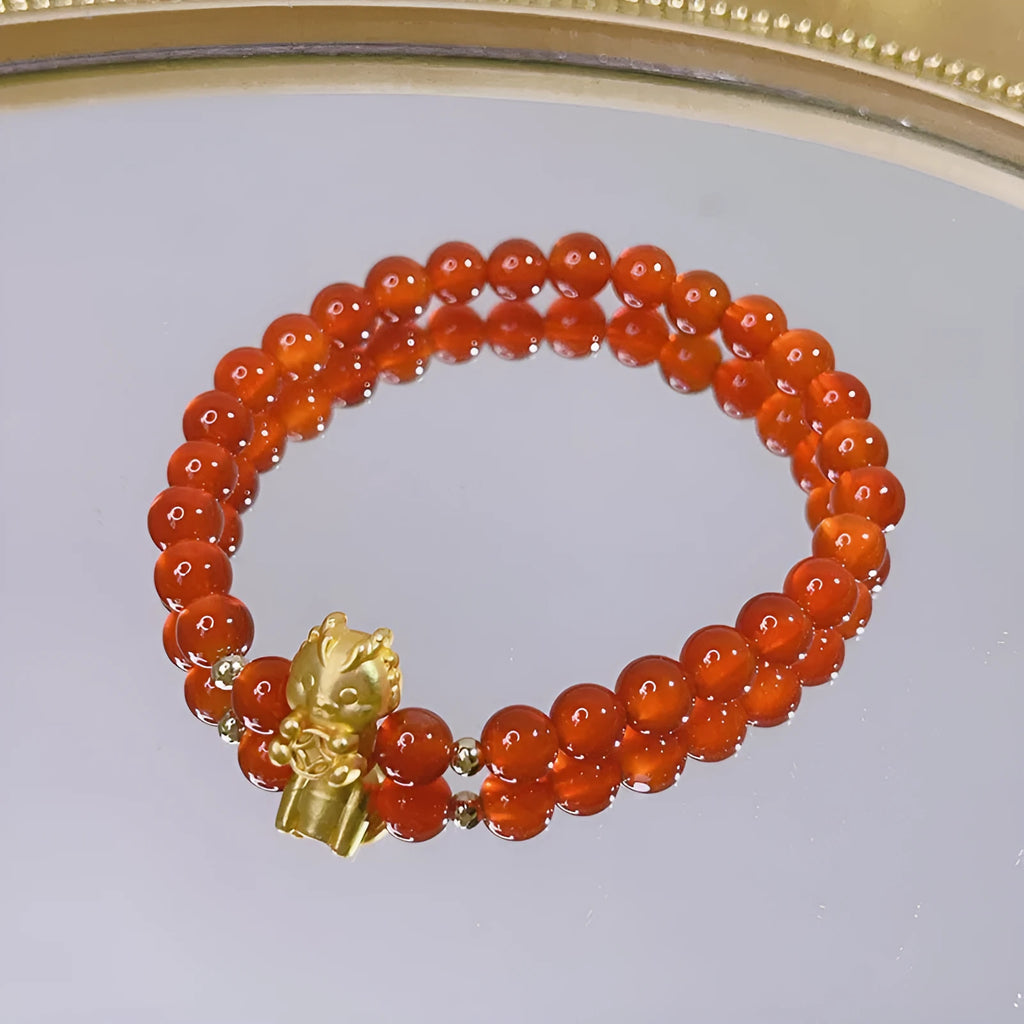 Women's handcrafted red agate bracelet with Chinese dragon design and lucky charm elements