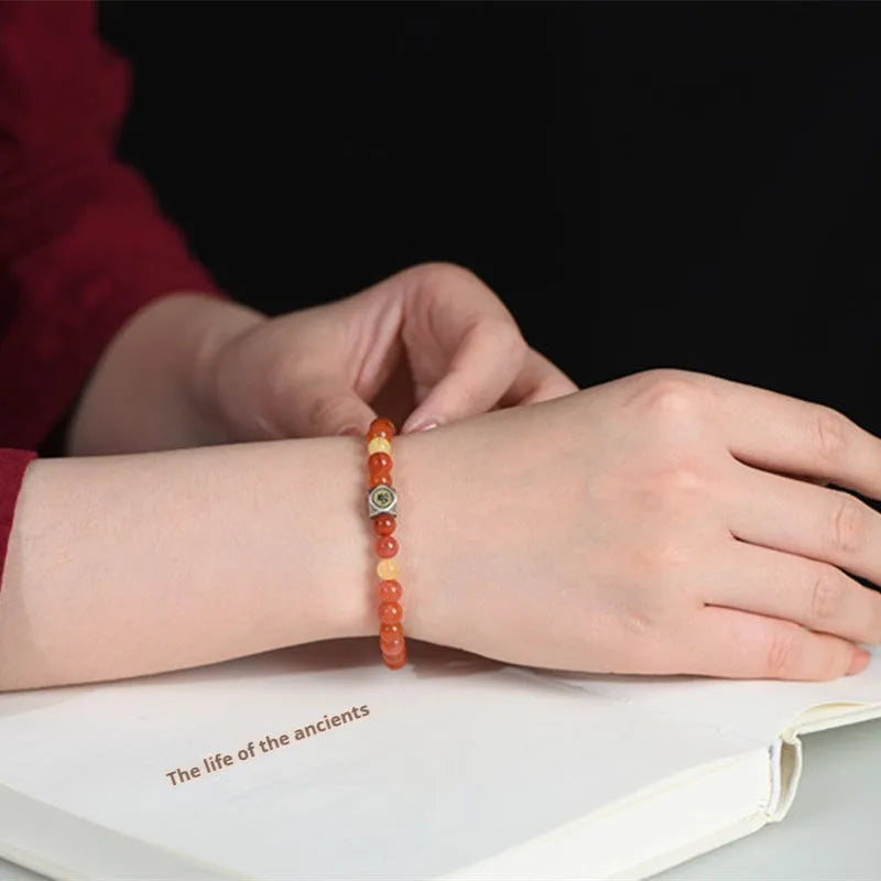 Natural Nanhong Agate zodiac bracelet with a beeswax bead, showing constellation design.