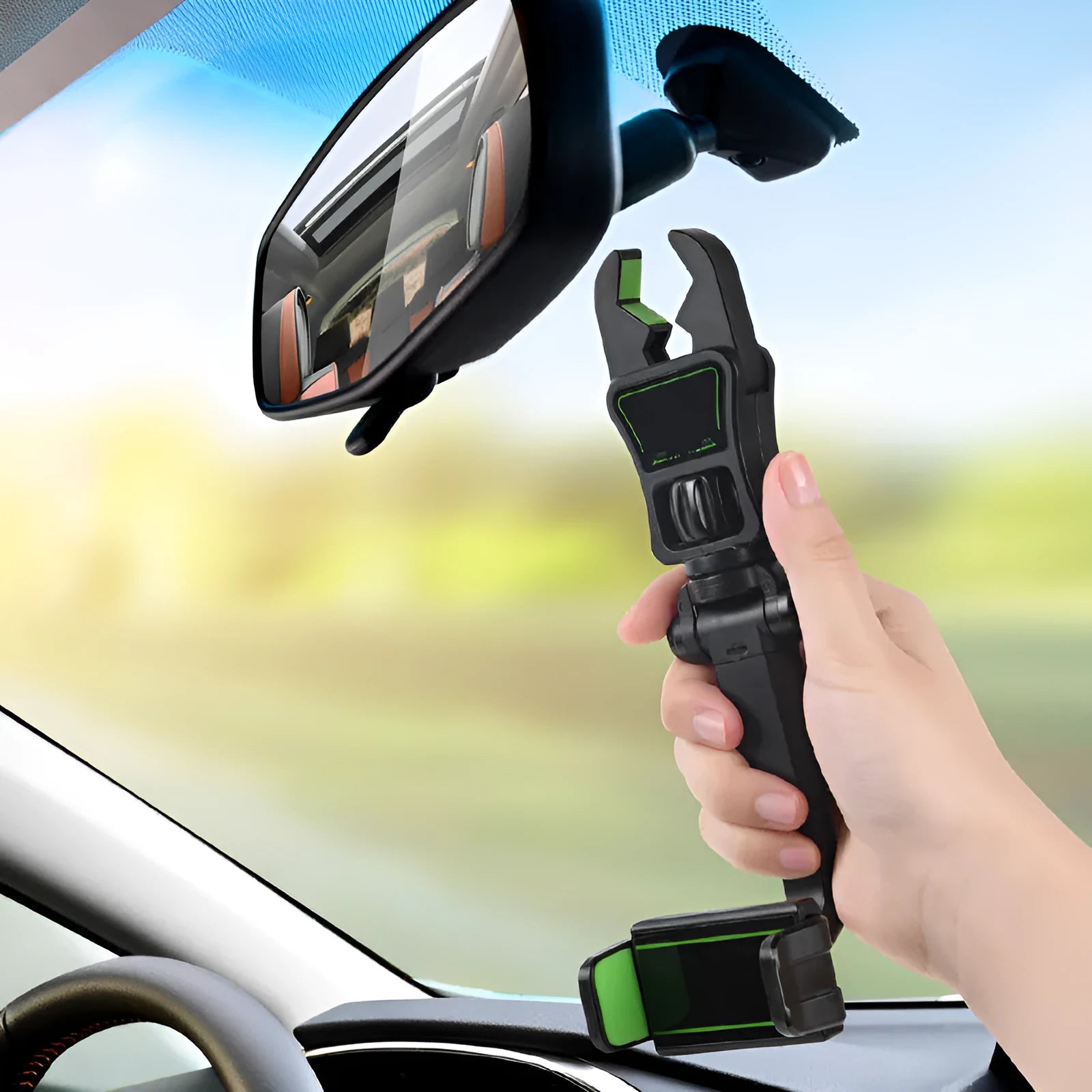 Black and green car phone holder attached to rear view mirror bracket